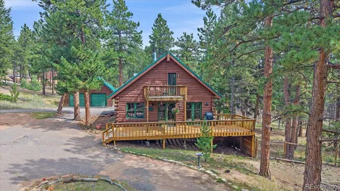a view of a house with a yard and large trees