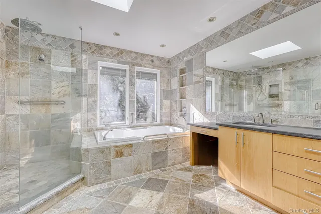a large bathroom with a tub sink shower and mirror
