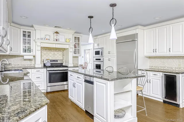 a kitchen with stainless steel appliances granite countertop a stove oven and white cabinets