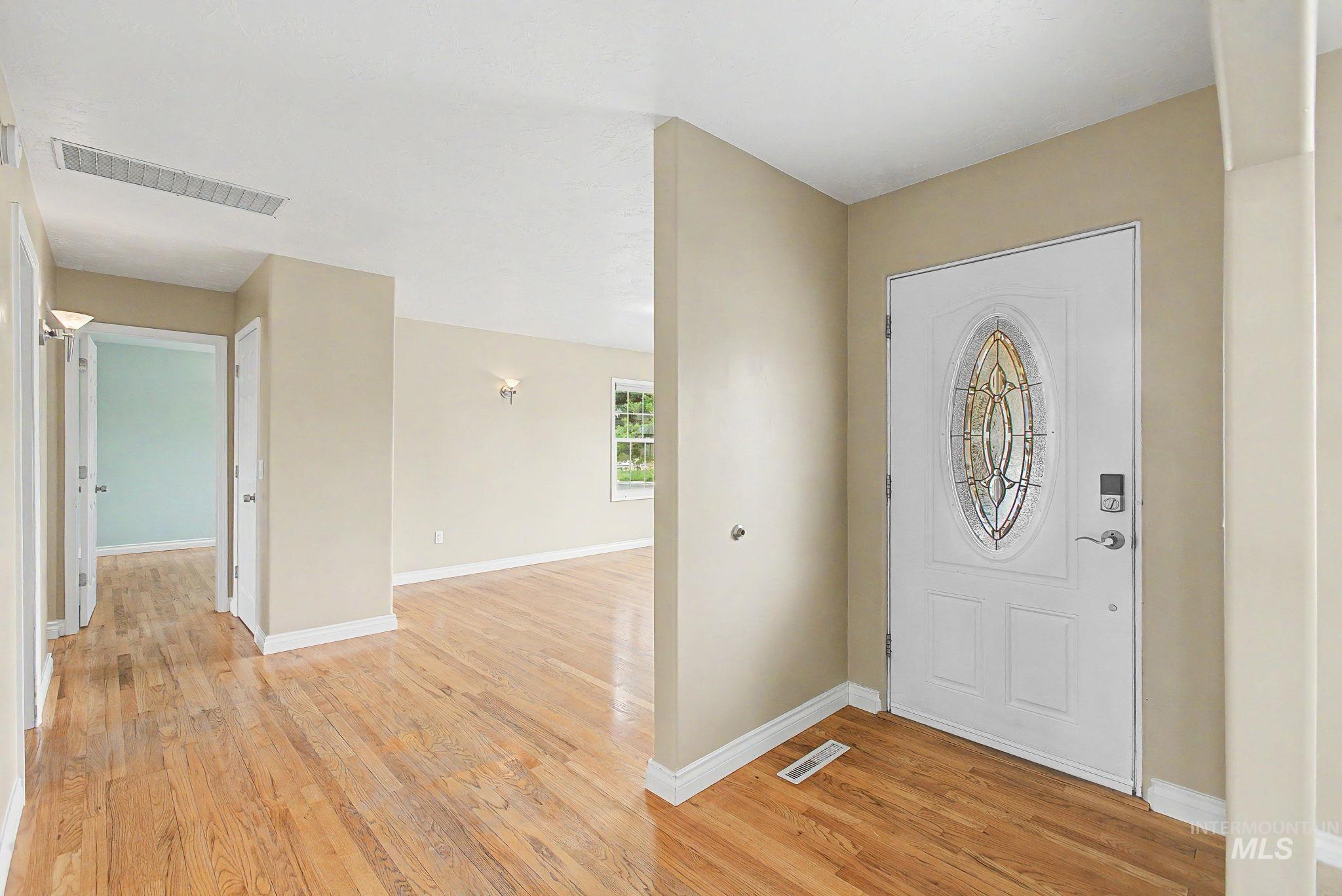 3314 6th Street Lewiston, ID 83501 - Photo 6 of 50 Entryway featuring a white paneled door with an oval stained glass insert, wood-finish flooring, and neutral wall tones