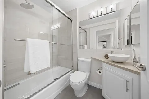 a bathroom with a sink toilet vanity granite tub and shower
