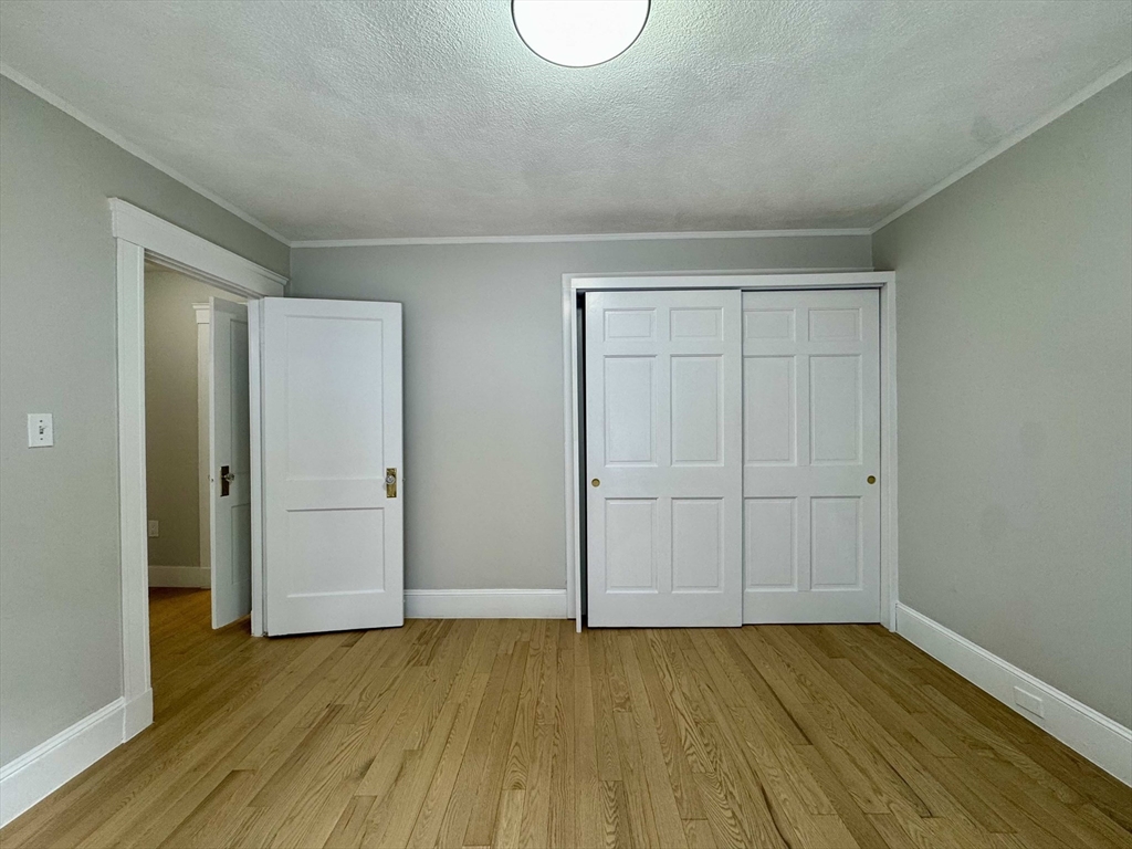 42 Chester Road, Unit 1 Belmont, MA 02478 - Photo 13 of 22 a view of an empty room with wooden floor and a window