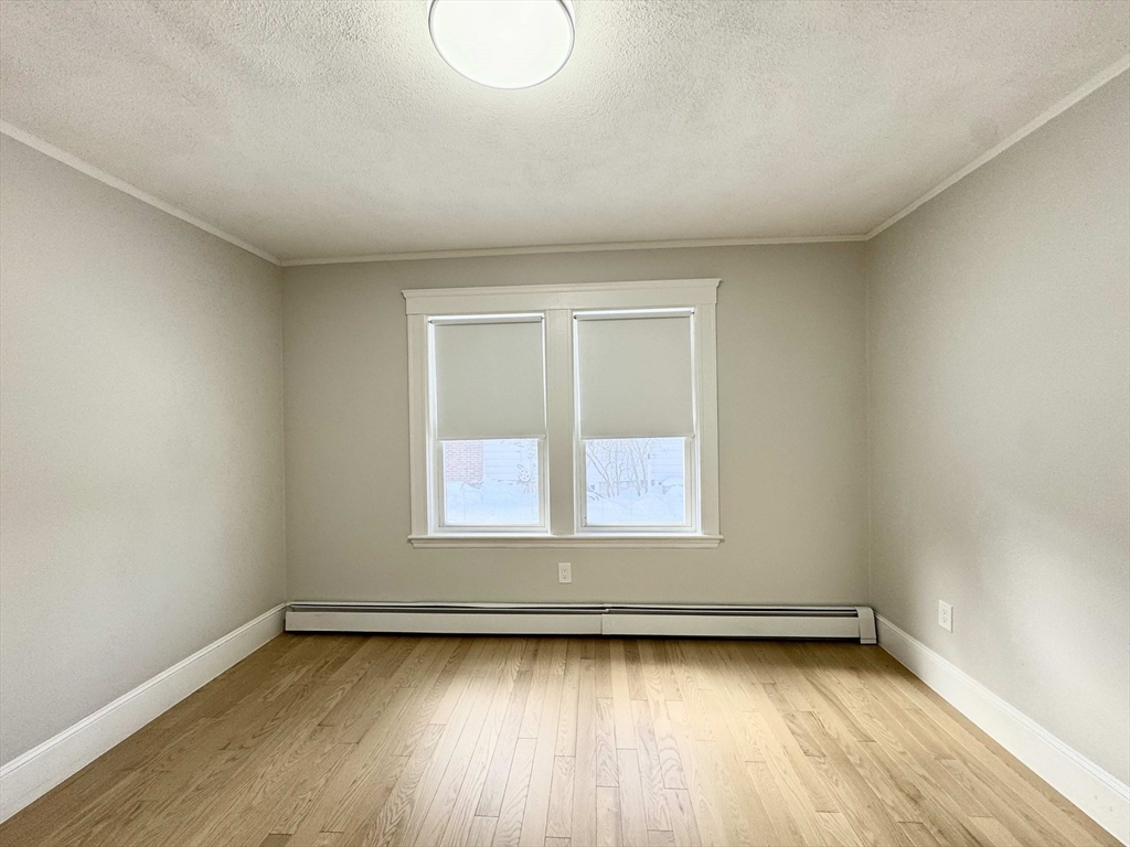 42 Chester Road, Unit 1 Belmont, MA 02478 - Photo 14 of 22 an empty room with wooden floor and windows