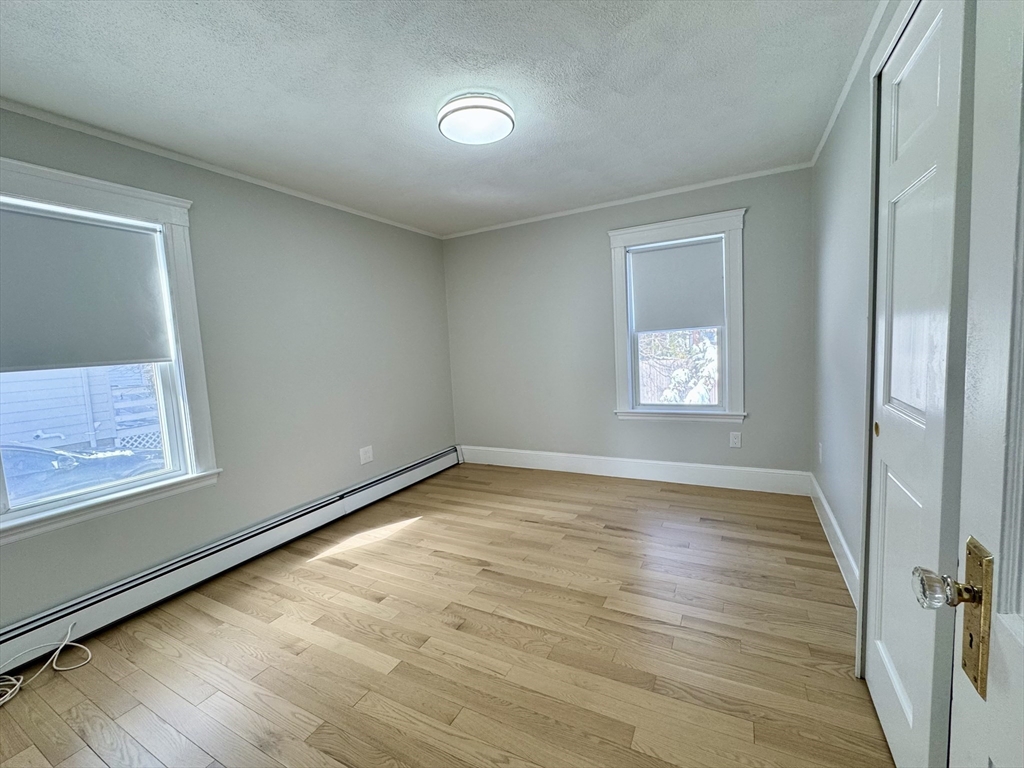 42 Chester Road, Unit 1 Belmont, MA 02478 - Photo 16 of 22 an empty room with wooden floor and windows