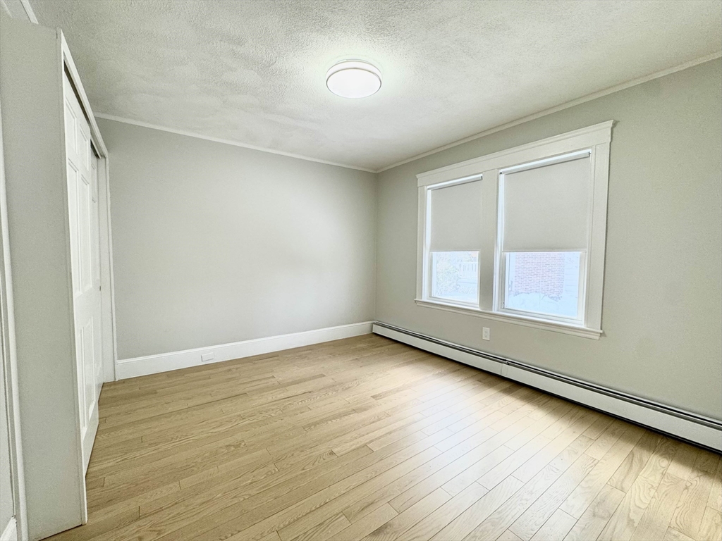 42 Chester Road, Unit 1 Belmont, MA 02478 - Photo 17 of 22 an empty room with wooden floor and windows