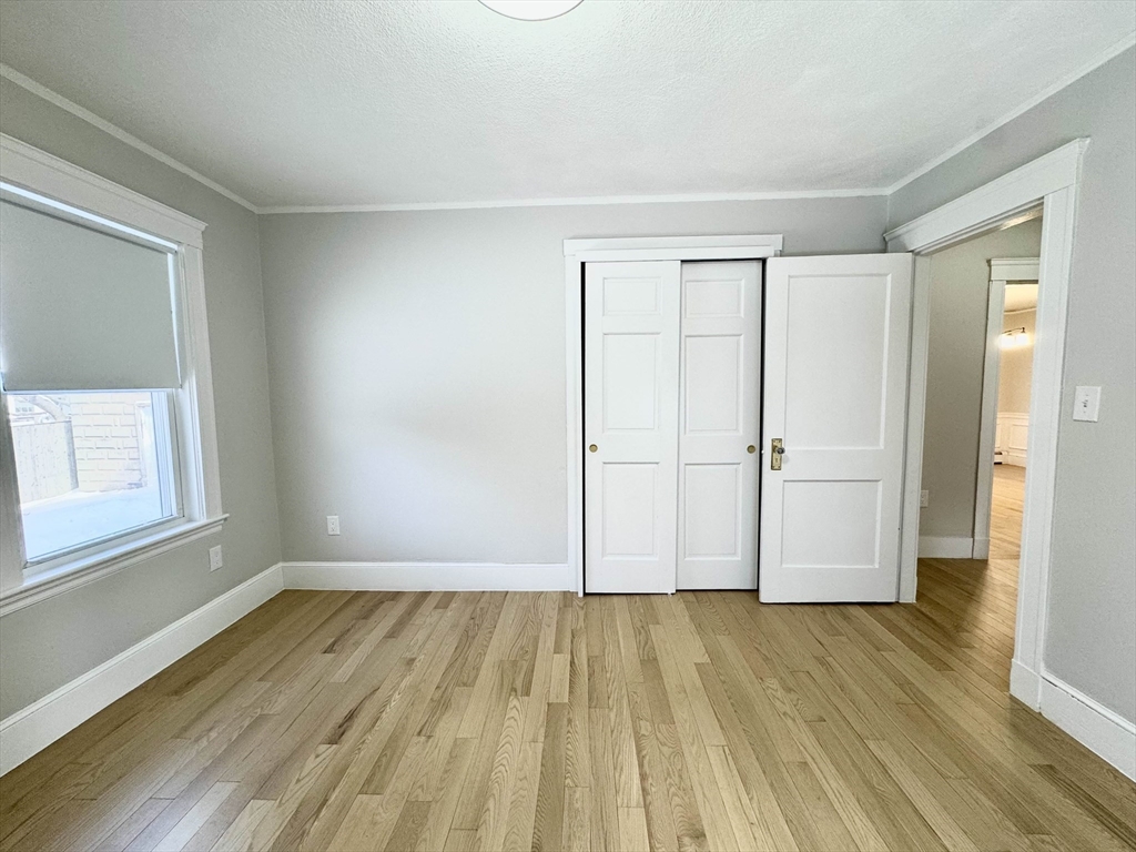 42 Chester Road, Unit 1 Belmont, MA 02478 - Photo 18 of 22 a view of a room with wooden floor and white walls