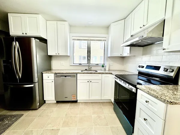 a kitchen with stainless steel appliances granite countertop a refrigerator stove and sink