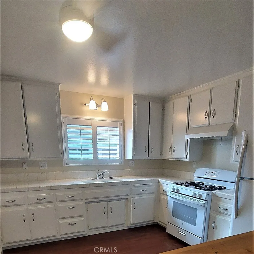 34529 Via Verde Dana Point, CA 92624 - Photo 6 of 18 a kitchen with granite countertop a stove a sink and a dishwasher with wooden cabinets