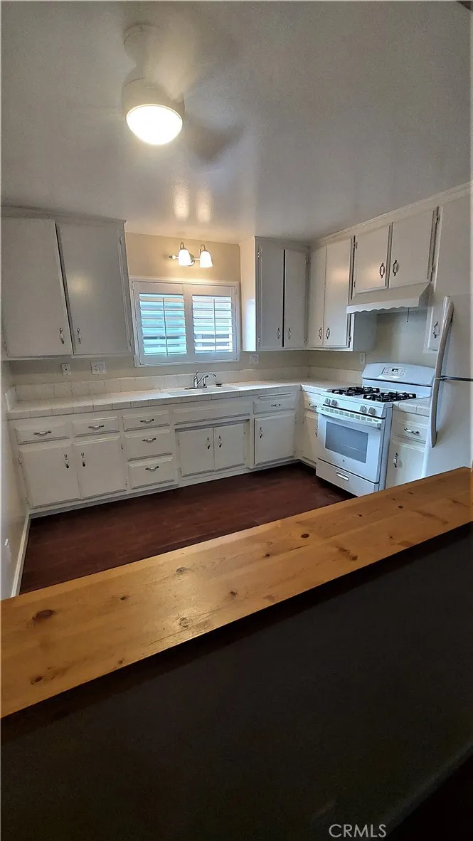 34529 Via Verde Dana Point, CA 92624 - Photo 7 of 18 a kitchen with granite countertop a sink a stove wooden floor and cabinets