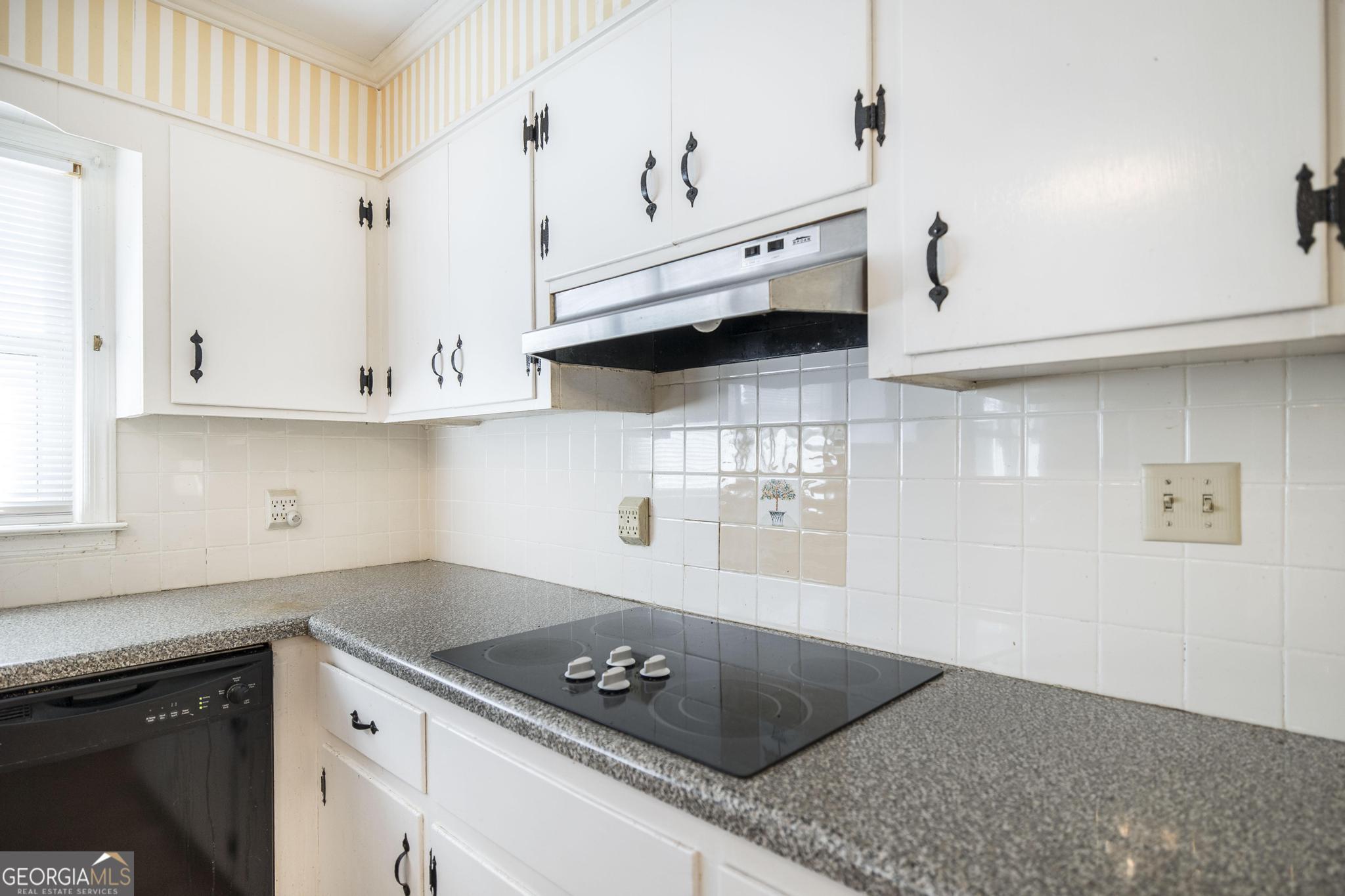1739 Houston Lake Road Perry, GA 31069 - Photo 11 of 34 a kitchen with white cabinets and a stove with wooden floor