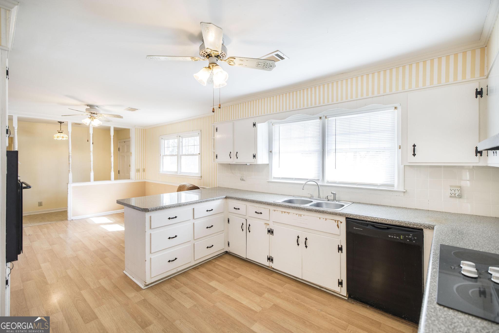 1739 Houston Lake Road Perry, GA 31069 - Photo 13 of 34 a kitchen with granite countertop a stove a sink and white cabinets with wooden floor