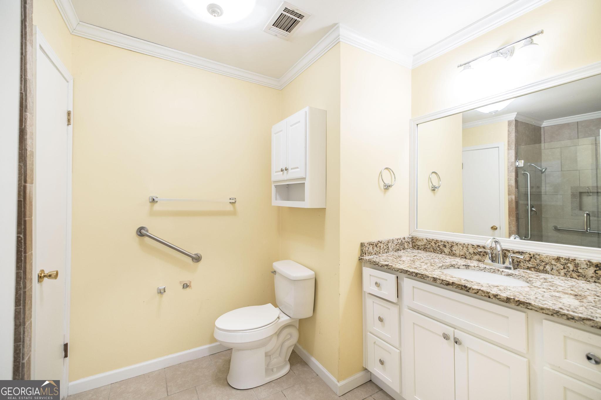 1739 Houston Lake Road Perry, GA 31069 - Photo 23 of 34 a bathroom with a granite countertop sink a toilet and a mirror