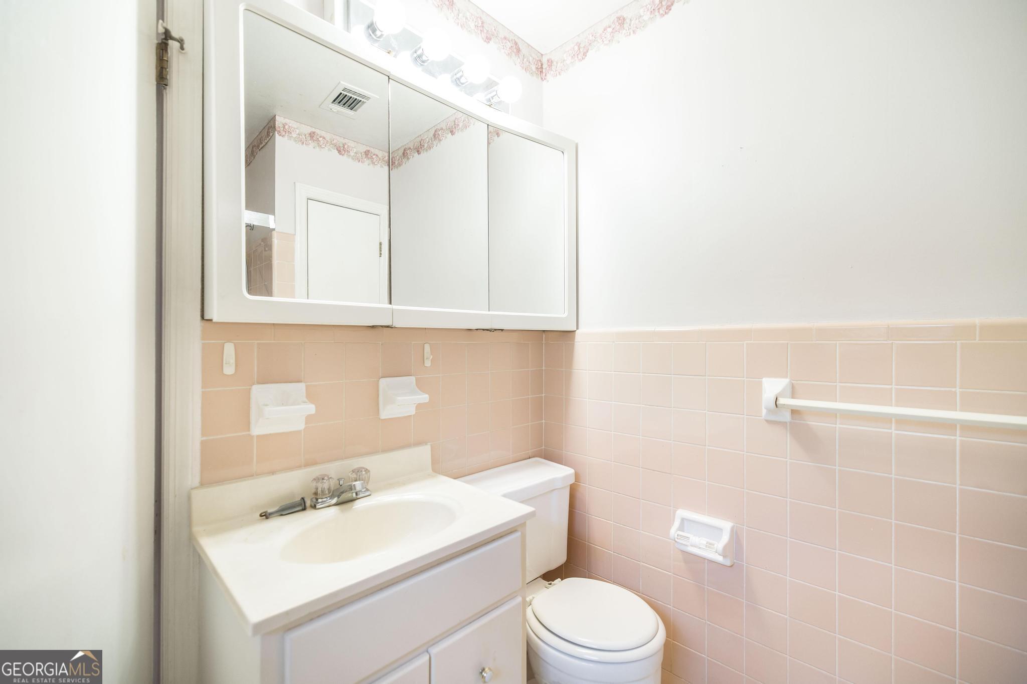 1739 Houston Lake Road Perry, GA 31069 - Photo 30 of 34 a bathroom with a sink a toilet and mirror