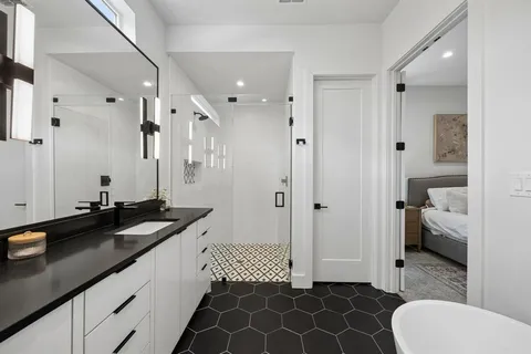 a spacious bathroom with a granite countertop sink and a mirror
