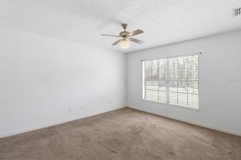 6355 East Rush Street Inverness, FL 34452 - Photo 11 of 27 an empty room with chandelier fan and windows