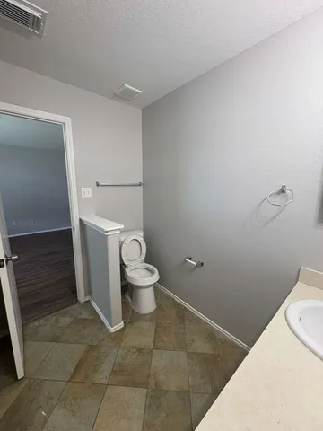 a white toilet sitting next to a bathroom sink