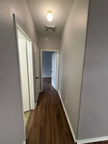 a view of a hallway with wooden floor and staircase