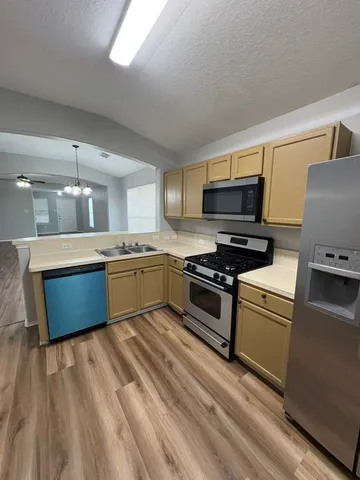 a kitchen with stainless steel appliances a sink and a microwave