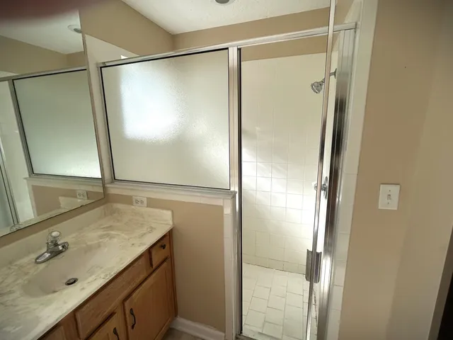 a bathroom with a shower sink and mirror