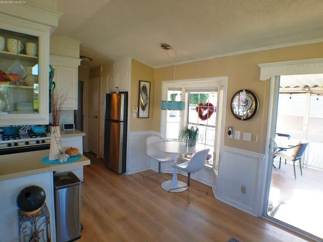 a view of a kitchen with refrigerator and white cabinets