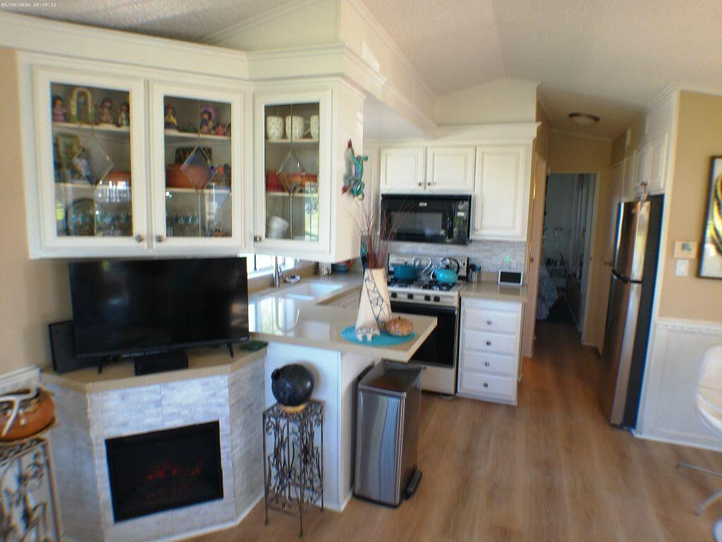 84136 Ave 44, Unit 262 Indio, CA 92203 - Photo 29 of 60 a kitchen with stainless steel appliances a stove a microwave and a refrigerator
