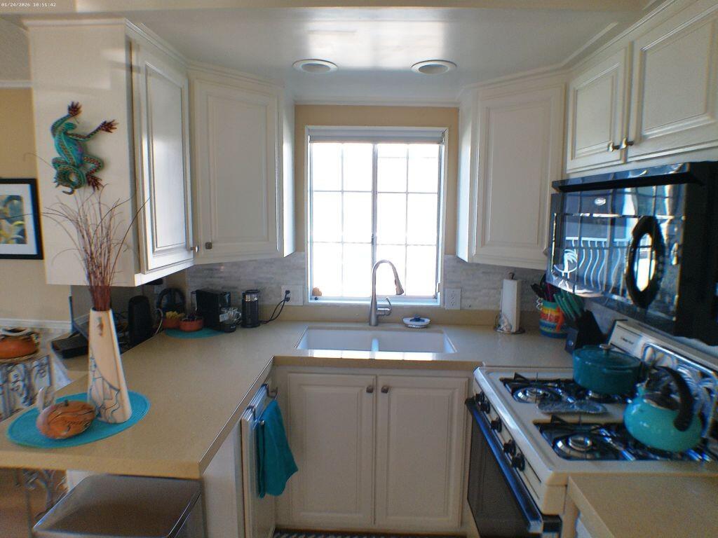 84136 Ave 44, Unit 262 Indio, CA 92203 - Photo 37 of 60 a kitchen with sink a stove and cabinets