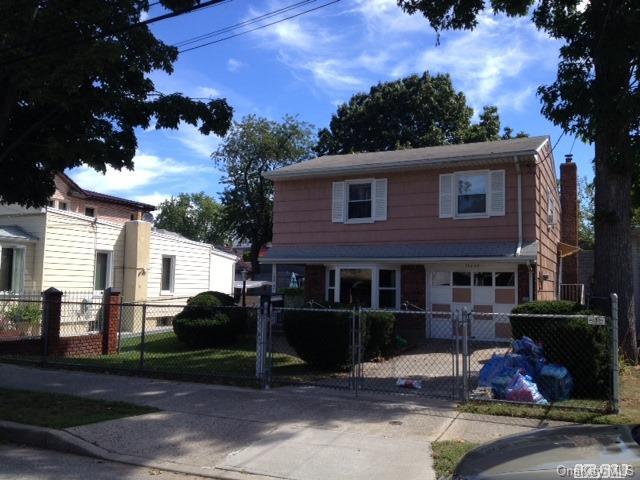 a front view of a house with a garden and plants