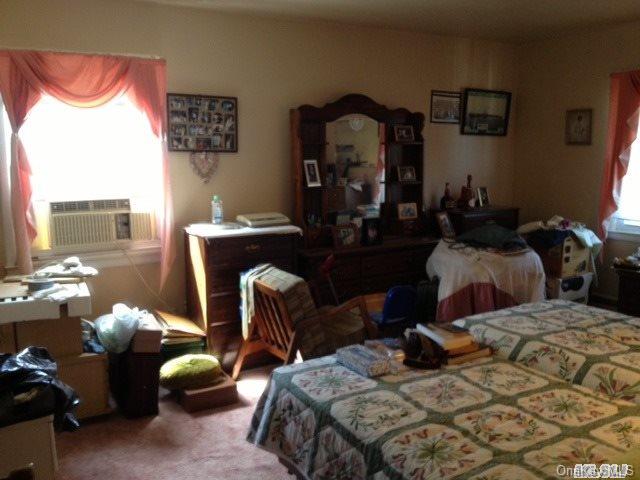 135-47 124th Street Queens, NY 11420 - Photo 15 of 17 a bedroom with bed a mirror and a large window