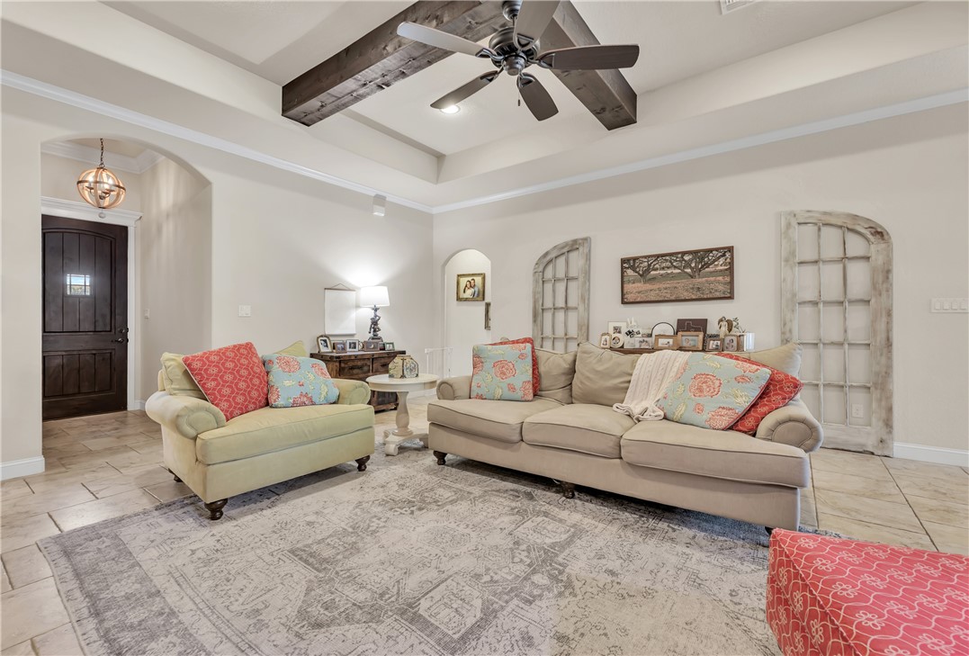 8312 Raintree Drive College Station, TX 77845 - Photo 6 of 30 Spacious living area featuring a tray ceiling with exposed wood beams and a ceiling fan