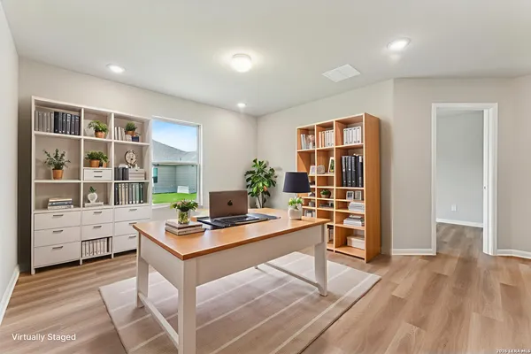a view of kitchen with kitchen island a sink wooden floor and a refrigerator