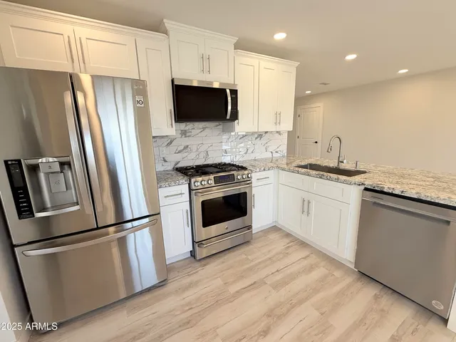 a kitchen with stainless steel appliances a refrigerator sink and microwave