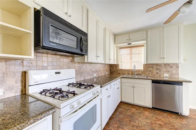 a kitchen with a sink stove top oven and cabinets