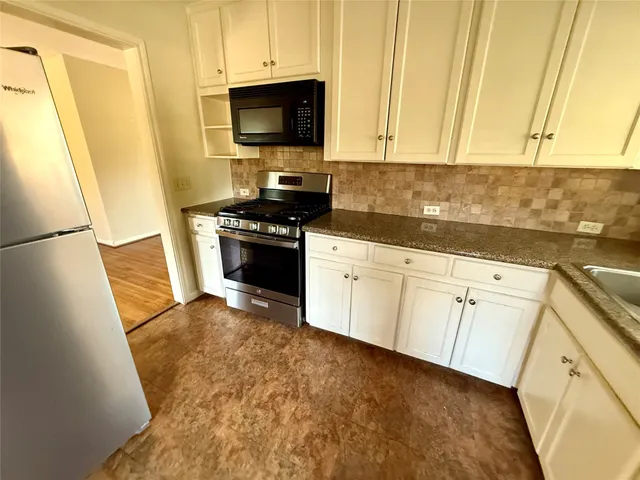 a kitchen with white cabinets sink and stainless steel appliances