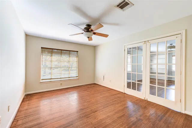 a view of an empty room with a window and wooden floor