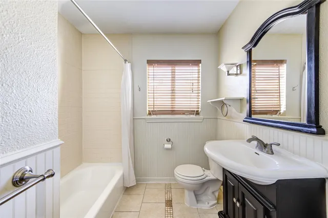 a bathroom with a sink toilet a mirror and bathtub