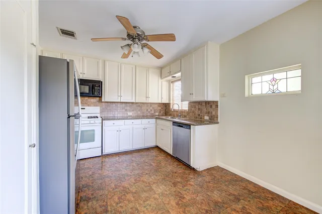 a kitchen with stainless steel appliances a refrigerator sink and microwave