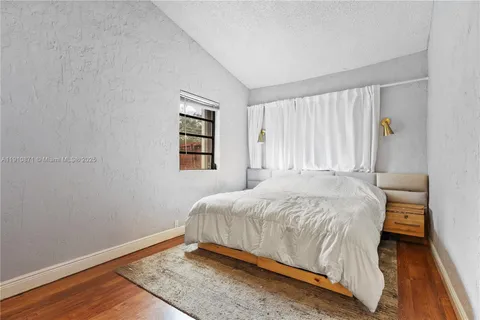 a bed sitting in a spacious bedroom next to a window