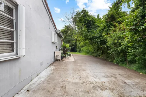 a view of a house with a backyard and a tree