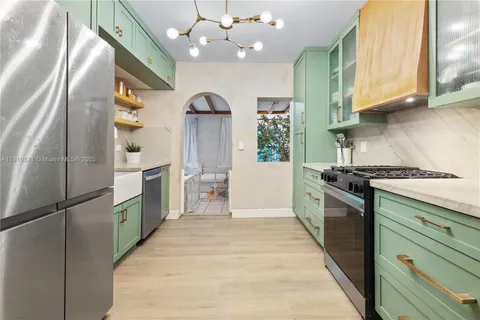 a kitchen with stainless steel appliances granite countertop a refrigerator a sink dishwasher a stove and a microwave oven with cabinets