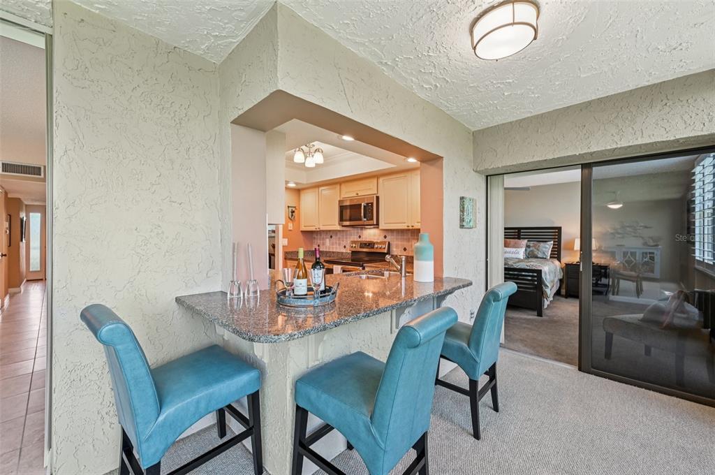 8710 Midnight Pass Road, Unit 203 Sarasota, FL 34242 - Photo 14 of 41 a dining room with furniture and wooden floor