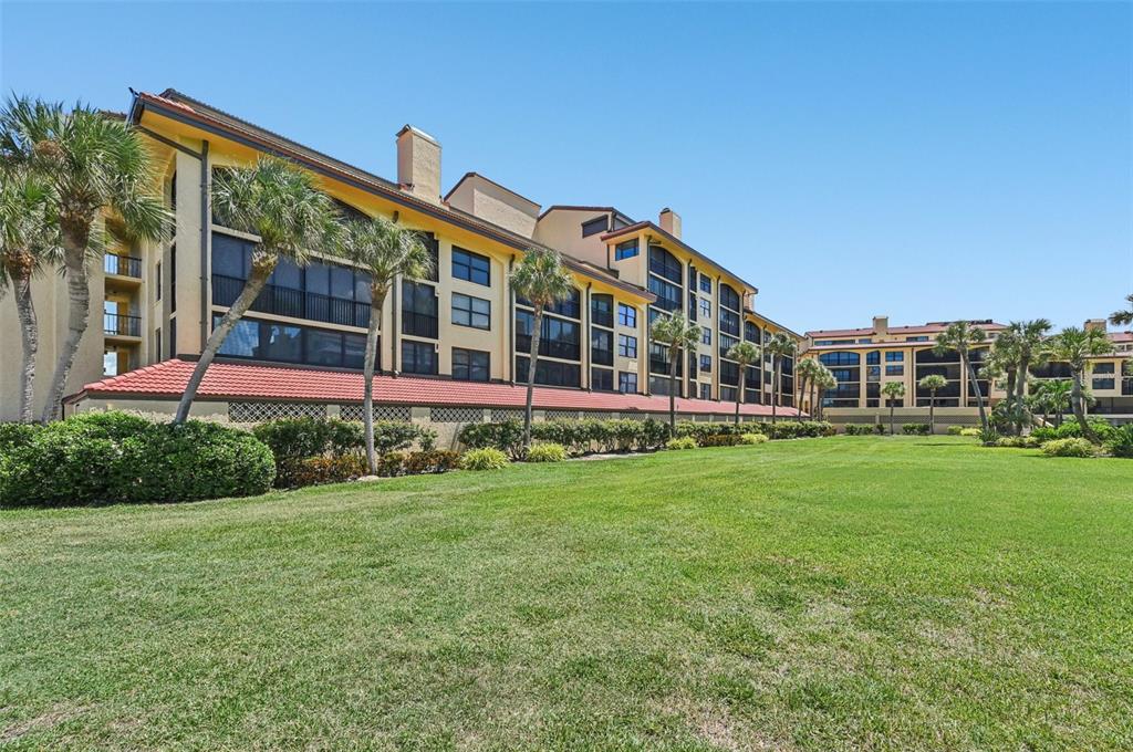8710 Midnight Pass Road, Unit 203 Sarasota, FL 34242 - Photo 38 of 41 a view of a big house with a big yard and large trees