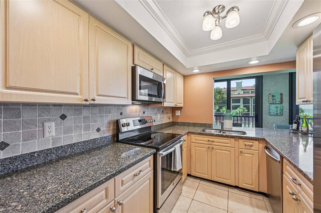8710 Midnight Pass Road, Unit 203 Sarasota, FL 34242 - Photo 10 of 41 a kitchen with a sink stove and microwave