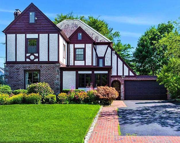 Tudor house featuring a front lawn and a garage