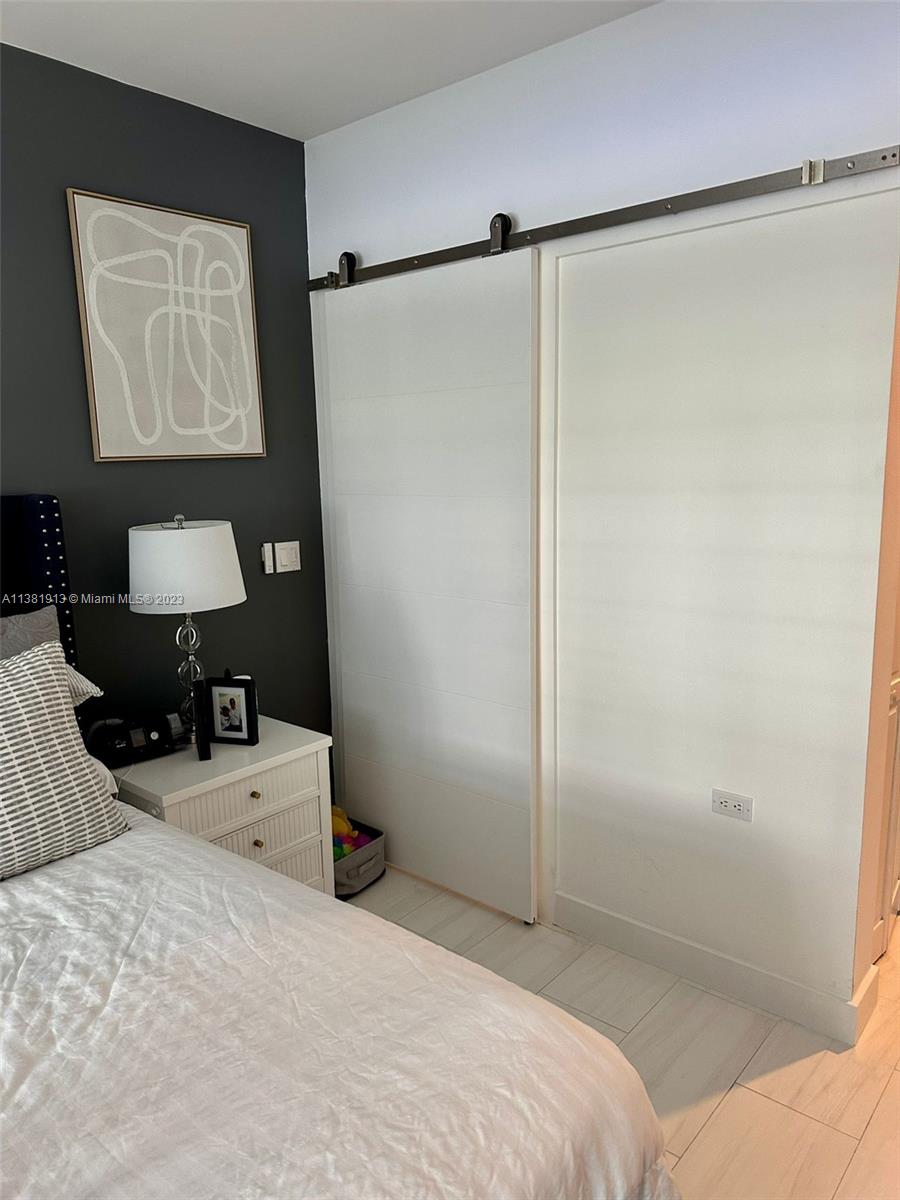 801 Brickell Key Boulevard, Unit 908 Miami, FL 33131 - Photo 15 of 29 a bedroom with a bed window and table chair
