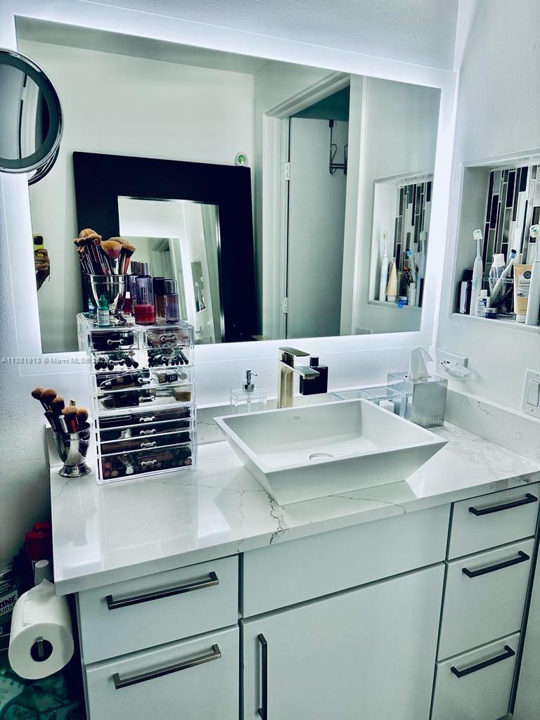 801 Brickell Key Boulevard, Unit 908 Miami, FL 33131 - Photo 19 of 29 a bathroom with a sink and a mirror