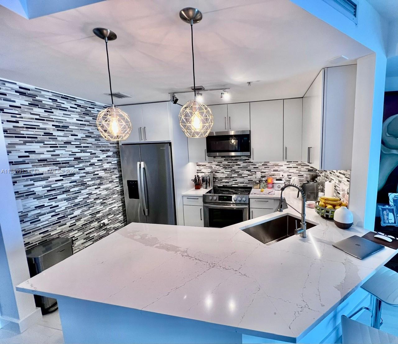 801 Brickell Key Boulevard, Unit 908 Miami, FL 33131 - Photo 5 of 29 a kitchen with stainless steel appliances kitchen island granite countertop a sink a counter top space cabinets and stainless steel appliances