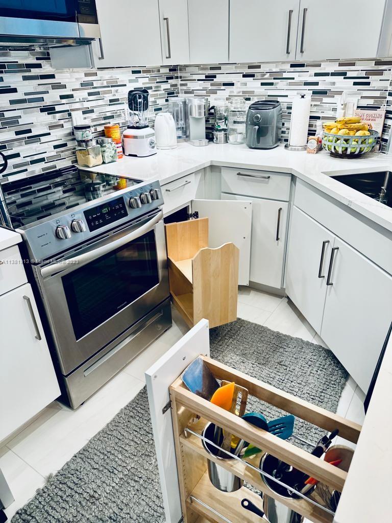 801 Brickell Key Boulevard, Unit 908 Miami, FL 33131 - Photo 7 of 29 a white stove sitting inside of a kitchen with stainless steel appliances granite countertop a stove and a sink