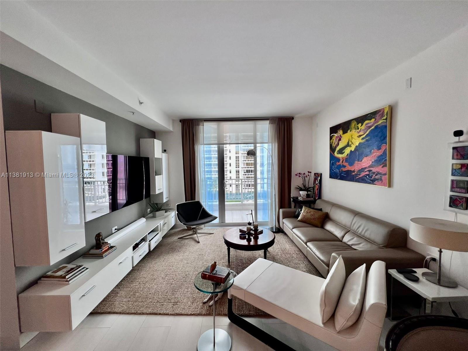 801 Brickell Key Boulevard, Unit 908 Miami, FL 33131 - Photo 8 of 29 a living room with furniture flat screen tv and a large window