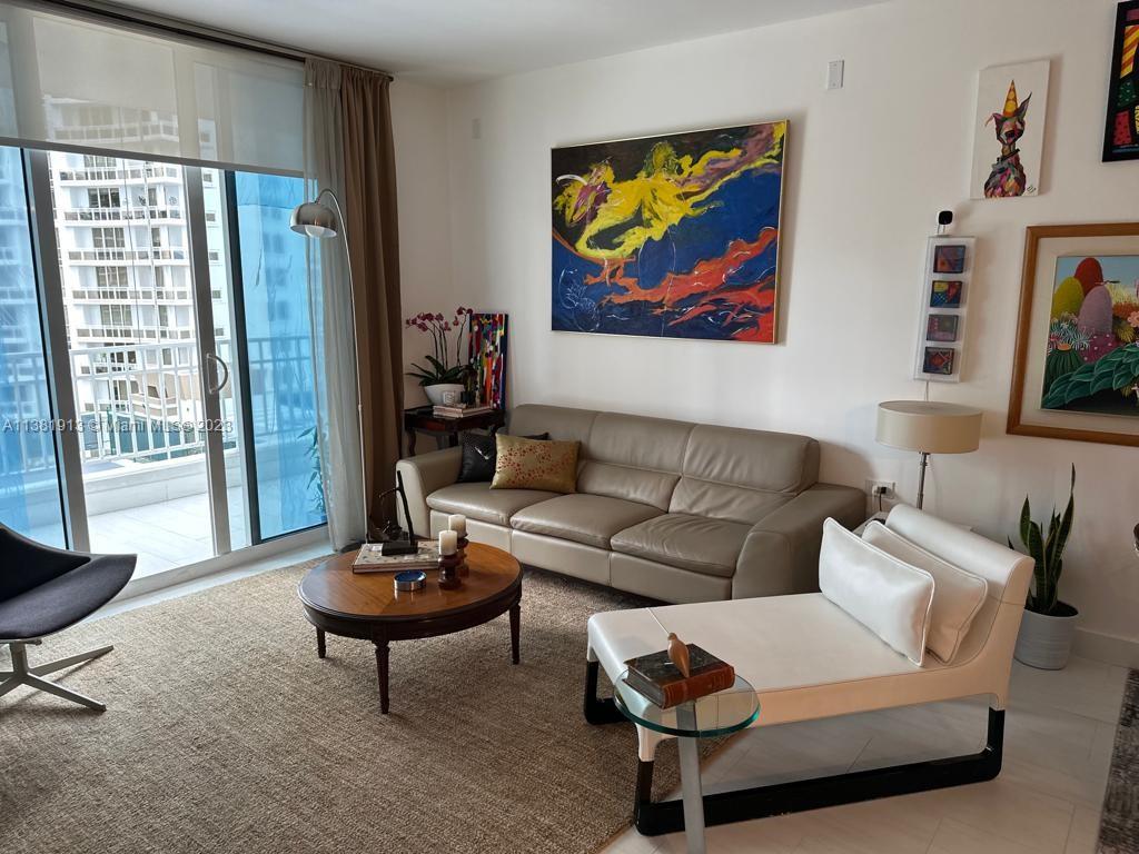 801 Brickell Key Boulevard, Unit 908 Miami, FL 33131 - Photo 10 of 29 a living room with furniture a lamp and a large window
