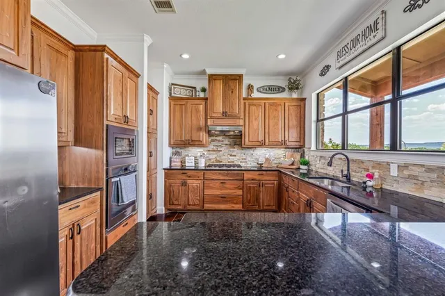 a kitchen with granite countertop a sink and a window